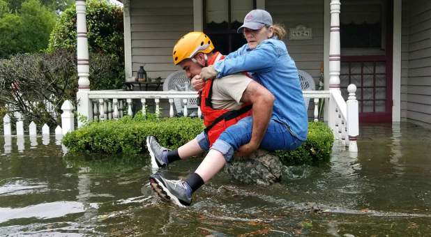A Texas National Guardsman carries a resident from her flooded home following Hurricane Harvey in Houston.